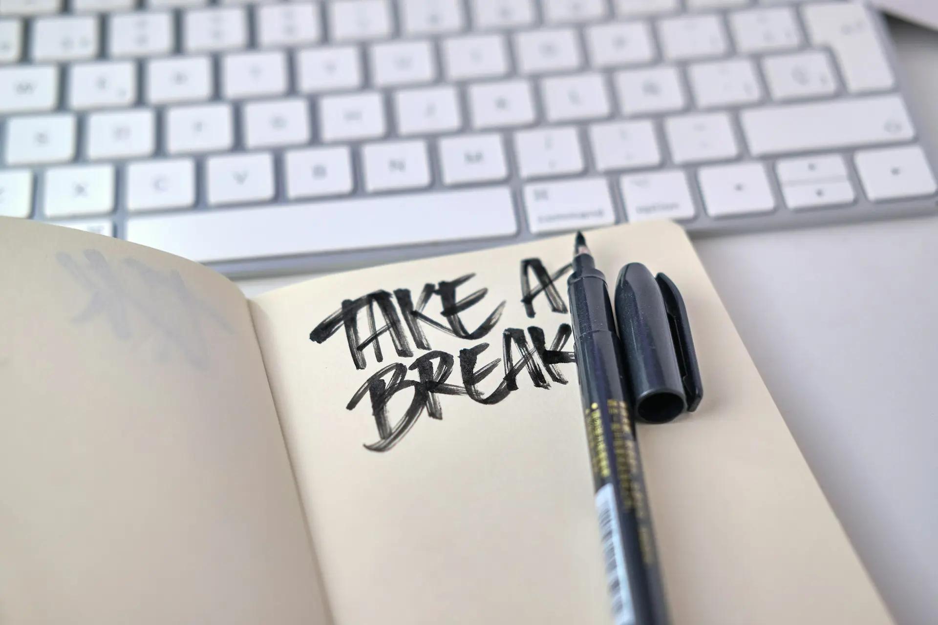 a notebook with some writing on it next to a keyboard